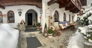 a porch of a building with snow on the ground at Gästehaus Sissy in Längenfeld