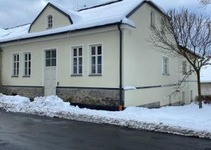 ein weißes Haus mit Schnee drauf in der Unterkunft Ubytování v centru Kašperských Hor in Kašperské Hory