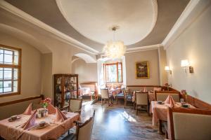 uma sala de jantar com mesas e cadeiras e um lustre em Renaissancehotel Raffelsberger Hof B&B em Weissenkirchen in der Wachau