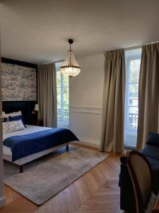 ein Schlafzimmer mit einem blauen Bett und einem Kronleuchter in der Unterkunft Château De La Bûcherie in Saint-Cyr-en-Arthies