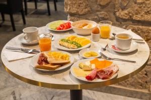 uma mesa coberta com pratos de alimentos e bebidas ao pequeno-almoço em Hotel Boréal Nice em Nice