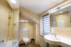 La salle de bains est pourvue d'un lavabo, de toilettes et d'une douche. dans l'établissement Victory Home Rooms, à Varsovie