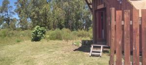 een houten kruk buiten een gebouw bij Chacrita Aguaribay in Villa Argentina