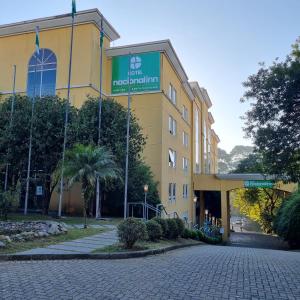 a yellow building with a sign on it at Hotel Nacional Inn Curitiba Santa Felicidade in Curitiba