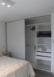 a white bedroom with a bed and a closet at Departamentos Ciudad de Nieva in San Salvador de Jujuy