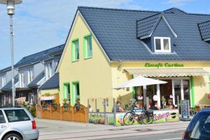 Un bâtiment jaune avec des personnes assises à l'intérieur dans l'établissement Hotel Sonne am Meer, à Norddeich