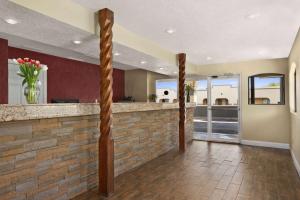 eine Lobby mit einer Backsteinbar mit Blumen in einer Vase in der Unterkunft Travelodge by Wyndham Clovis in Clovis