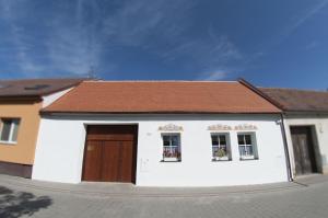 une petite maison blanche avec un toit marron dans l'établissement Slovácká chalupa, à Strážnice