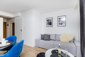 a living room with a gray couch and blue chairs at Grapa Ski - apartament Białka Tatrzańska in Białka Tatrzanska