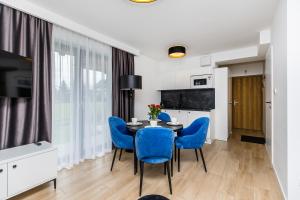 a dining room with a table and blue chairs at Grapa Ski - apartament Białka Tatrzańska in Białka Tatrzanska