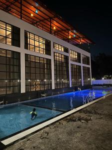 uma pessoa numa piscina em frente a um edifício em Krown Palace Resort em Silvassa