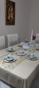 a table with a white table cloth with dishes on it at Panoramic apartment in Shkodër