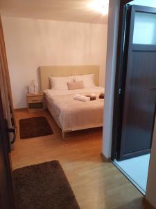 um quarto com uma cama com lençóis brancos e almofadas em NANA"S HOUSE APARTAMENT 2 Camere,2 bai em Sibiu