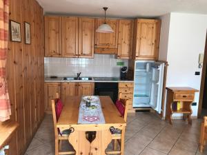 a kitchen with wooden cabinets and a wooden table at Appartamento Monte Rosa in Champoluc