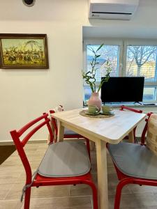 - une table à manger avec 2 chaises rouges et un bureau dans l'établissement The Industrial Loft, à Ljubljana