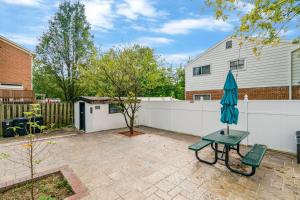 eine Terrasse mit einem Sonnenschirm und einem Zaun in der Unterkunft Escape to our cozy 3 Bed Rm 2 Bath Unit in Alexandria VA in Alexandria