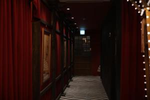 a hallway with red walls and a black and white striped floor at Aank Ryokan Yosuriguri Hotel in Cheonan