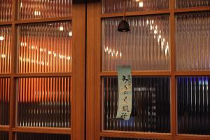 a window with a sign on it in a room at Aank Ryokan Yosuriguri Hotel in Cheonan