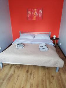 een slaapkamer met een bed met een rode muur bij Emilka in Suwałki