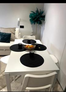 バレンシナ・デ・ラ・コンセプシオンにあるApartamento a 8km Sevilla centroの白いテーブル(カップ2杯、フルーツ1杯付)