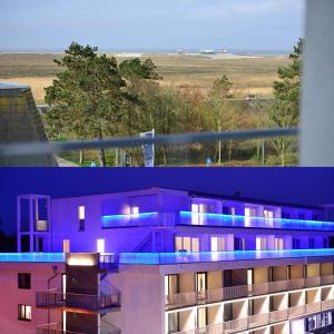 een paars gebouw met blauwe lichten erop bij Parkhotel Residenz in Sankt Peter-Ording