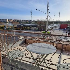 een tafel en stoelen op een balkon met een straat bij Center Macon charmant appartement avec vue sur la Saone in Mâcon