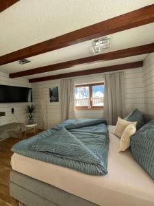 um quarto com uma cama grande e uma janela em Ferienwohnung Jägerheim em Bürserberg