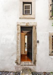 un ingresso a un edificio bianco con porta di Casa Aurora - bairro típico a minutos do Terreiro a Lisbona