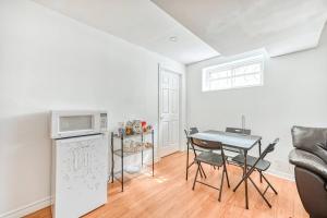 een keuken en eetkamer met een tafel en een magnetron bij Leila's Place-Family Deluxe Basement Apartment in Gatineau