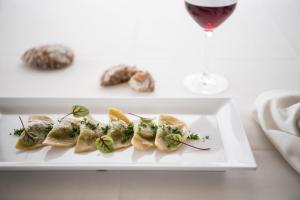 un piatto di cibo su un tavolo con un bicchiere di vino di Das Panorama Dependance a Caldaro