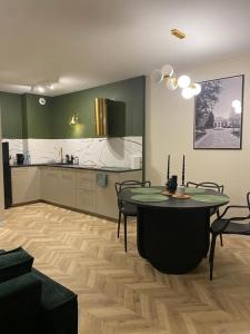 uma sala de estar com uma mesa e uma cozinha em Apartament Twój ZDRÓJ & SPA Dr Duda em Busko-Zdrój