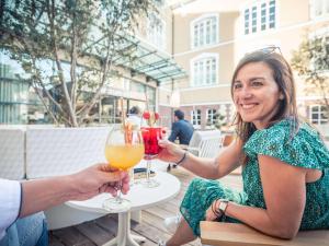 duas pessoas sentadas numa mesa com bebidas em Mercure Troyes Centre em Troyes