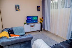 Uma TV ou centro de entretenimento em IT IS WELL HOMES