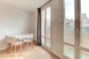 a white table and chairs in a room with a window at Le Petit Nid - Apt Lumineux en Hypercentre in Montigny-le-Bretonneux