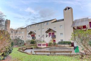 an exterior view of a building with a courtyard at Le Petit Nid - Apt Lumineux en Hypercentre in Montigny-le-Bretonneux