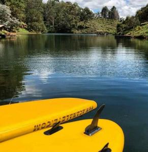 żółty kajak siedzący na wodzie w obiekcie Cabaña con jacuzzi y acceso al embalse Portum III w mieście El Peñol