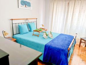 een slaapkamer met een bed met blauwe lakens en een tafel bij Pátio Privado com Churrasqueira by Férias em Figueira in Figueira da Foz