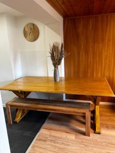 una mesa de madera con un jarrón con una planta en SNOW NEST: Superbe cocon enneigé, en Crans-Montana