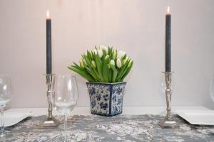 uma mesa com duas velas e um vaso com flores em Tunghoern Hues Wohnung 07 em Keitum