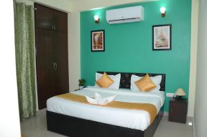 a bedroom with a large bed with a blue wall at Rumaisa Red in Noida