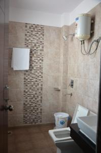 a bathroom with a shower and a toilet and a sink at Rumaisa Red in Noida