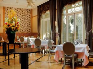 a restaurant with tables and chairs and a vase of flowers at Hotel Monterey Kyoto in Kyoto