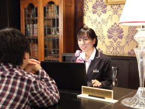 a woman sitting at a table with a man looking at a laptop at Hotel Monterey Kyoto in Kyoto