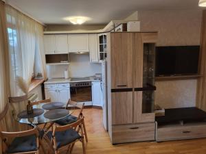 kuchnia z małym stołem oraz kuchnia z lodówką w obiekcie Apartamentai Taikos 10-36 Nida w mieście Nida