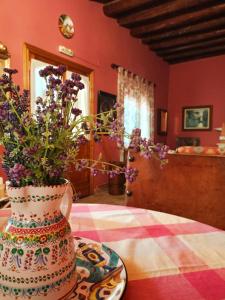 un jarrón lleno de flores púrpuras sentado en una mesa en Casa rural de la Abuela, en Cadreita