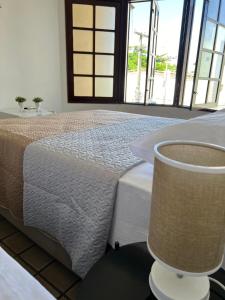 a bedroom with a bed and a large window at Pousada Mangai in João Pessoa