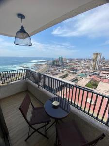 einen Balkon mit einem Tisch, Stühlen und Meerblick in der Unterkunft Surf and Relax Apartment in Iquique