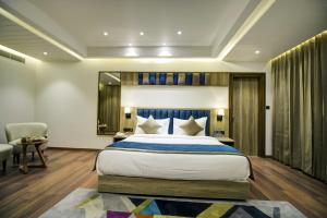 a bedroom with a large bed with a blue headboard at Cygnett Style Ganga in Jaipur