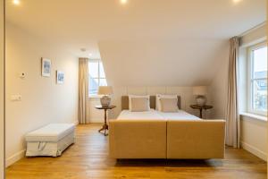 a bedroom with a large bed and two windows at Villa Zuiderduin in Zoutelande