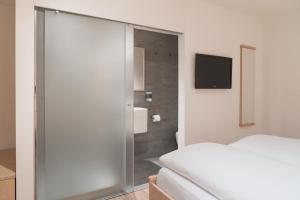 - une chambre avec une porte coulissante en verre menant à une douche dans l'établissement Lodge Brocco & Posta, à San Bernardino